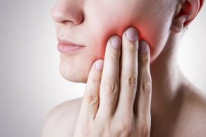 Woman with a toothache touching her face